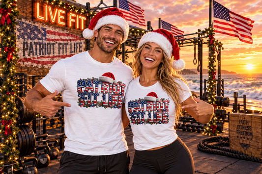 A man and a woman wearing matching white t-shirts with a 'Patriot Fit Life' graphic in an American flag pattern, standing in a decorated gym at sunset with Santa hats.