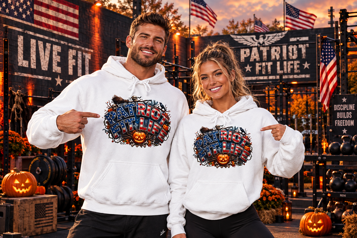A man and a woman wearing matching white hoodies with a large Halloween 'Patriot Fit Life' graphic on the front, posed in a gym setting with Halloween decorations, pumpkins, gym equipment, and American flags.