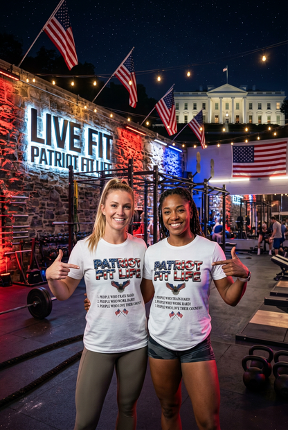 Two women posing together at night at an outdoor gym, wearing matching white t-shirts with a patriotic red, white, and blue 'PATRIOT FIT LIFE' graphic. The background features a stone wall with a large 'LIVE FIT PATRIOT FIT LIFE' sign, American flags, and a lit-up White House in the background.