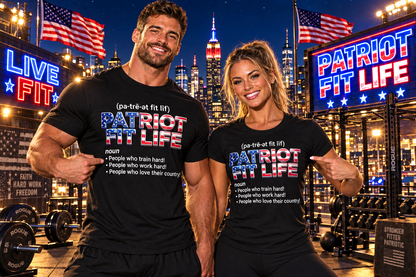 A man and a woman posing in a gym wearing matching black t-shirts with a patriotic-themed graphic that reads 'PATRIOT FIT LIFE' with a dictionary-style definition. The background shows a lit-up city skyline at night with American flags and gym equipment.