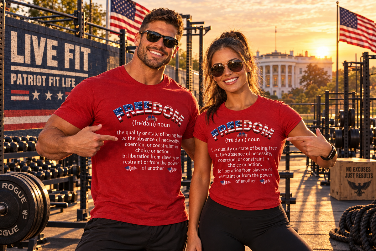 A smiling man and woman stand in a gym wearing matching red graphic T-shirts with a white printed definition of the word 'FREEDOM' and patriotic American flag motifs. The background shows a real outdoor gym environment with American flags, a barbell, ropes, and a sunset over the White House.