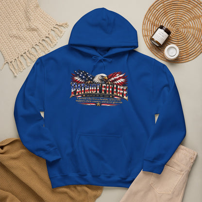 A royal blue pullover hoodie laid flat on a light beige surface, featuring a PATRIOT FIT LIFE dictionary-style definition graphic across the chest. 