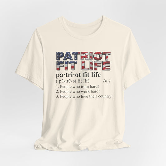 An off-white short-sleeve t-shirt with a graphic on the front. The graphic features the text 'PATRIOT FIT LIFE' styled with an American flag pattern, followed by the definition 'pa-tri fit life' and three definitions underneath in black text.