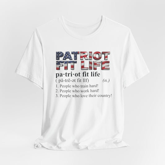 A white short-sleeve t-shirt with a graphic print on the front. The graphic features the words 'PATRIOT FIT LIFE' in a textured American flag pattern, followed by the definition 'pa-tri-ot fit life' and three listed meanings in black text, all set against a clean white background.
