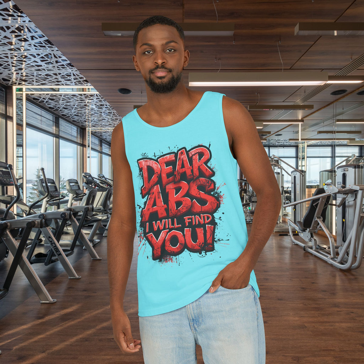 Man wearing a light blue tank top with red and black text in a gym setting