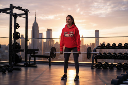 Red hoodie with 'EVERYTHING HURTS' text with a gym skyline background.