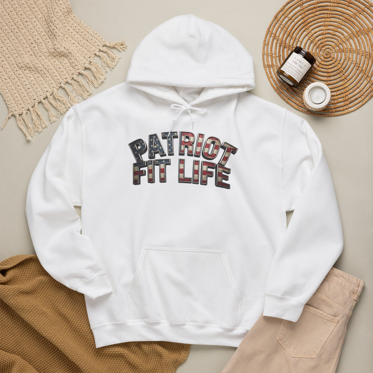 A white pullover hoodie laid flat with a front kangaroo pocket and a large arched 'PATRIOT FIT LIFE' text graphic across the chest. The graphic uses a plaid pattern with red, brown, black, and white tones.