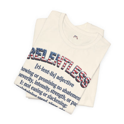 A folded cream-colored t-shirt featuring a graphic print of the word 'RELENTLESS' in an American flag pattern, with a dictionary definition printed below in dark blue text.