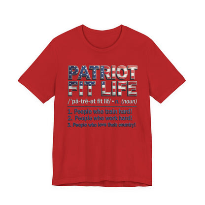 A red short-sleeve crewneck t-shirt featuring a patriotic-themed graphic on the front. The graphic reads 'PATRIOT FIT LIFE' in a distressed American flag pattern, followed by a phonetic pronunciation guide and three definitions listed below in dark blue text.