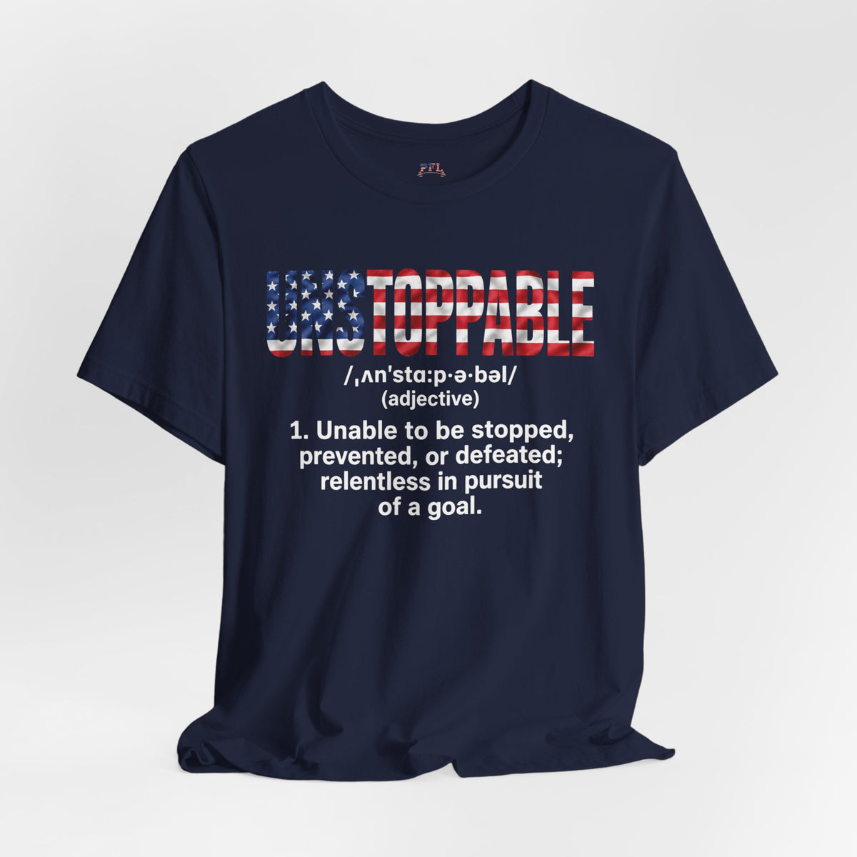 A navy blue short-sleeve t-shirt with a graphic on the chest. The graphic features the word 'UNSTOPPABLE' in a distressed American flag pattern (red, white, and blue) with a dictionary definition printed below in white text.