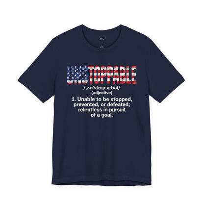 A navy blue short-sleeve t-shirt with a graphic on the chest featuring the word 'UNSTOPPABLE' in an American flag pattern and a dictionary definition printed below in white text.