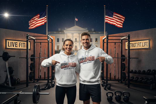 Two smiling people standing in an outdoor gym setting wearing matching white hoodies with a patriotic graphic that reads 'UNSTOPPABLE!' and 'Achieve Anything.' Behind them is a nighttime scene with American flags, weight racks, dumbbells, kettlebells, and a lit building facade resembling the White House.